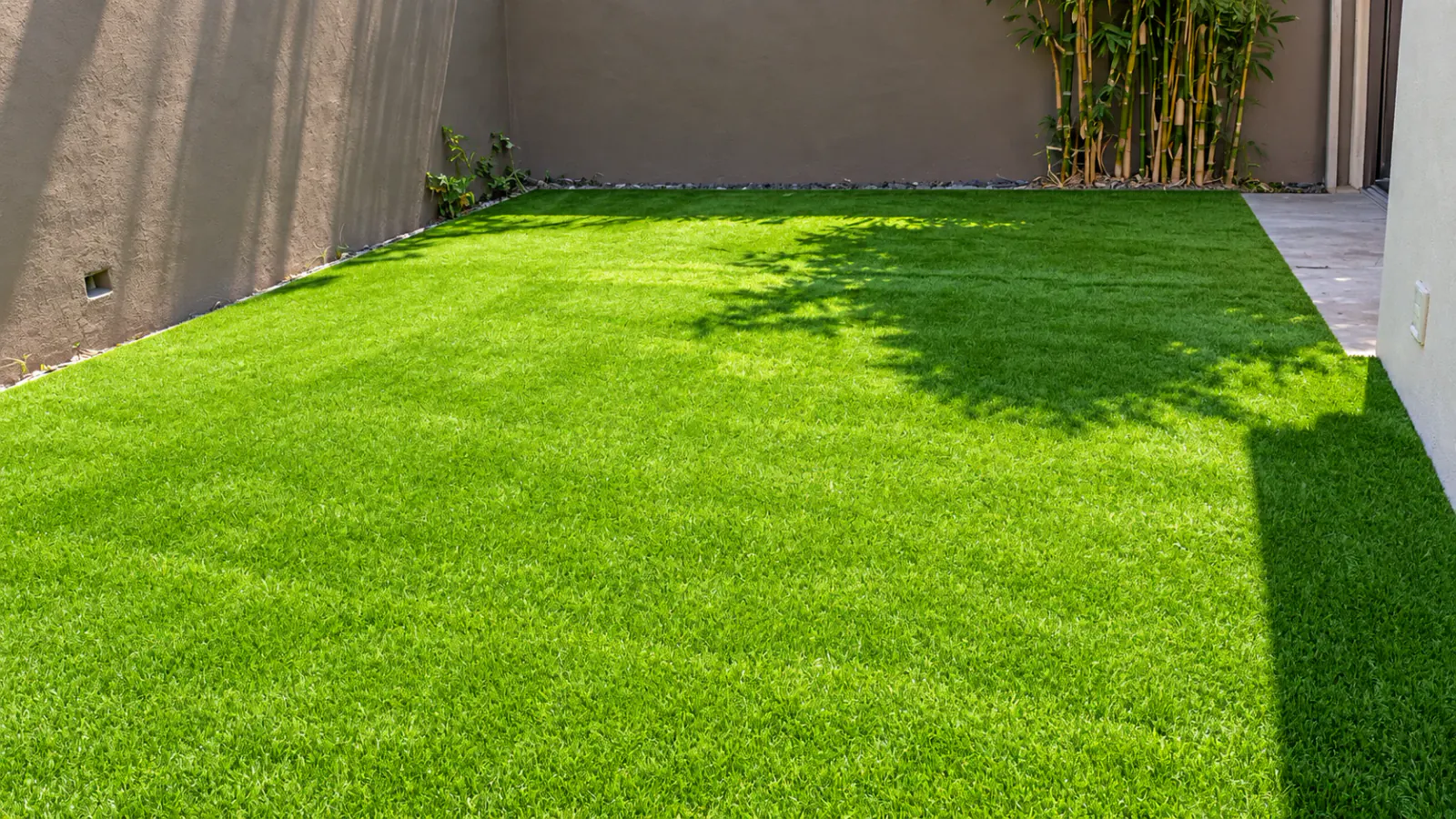 Patio residencial sombreado con pasto sintético