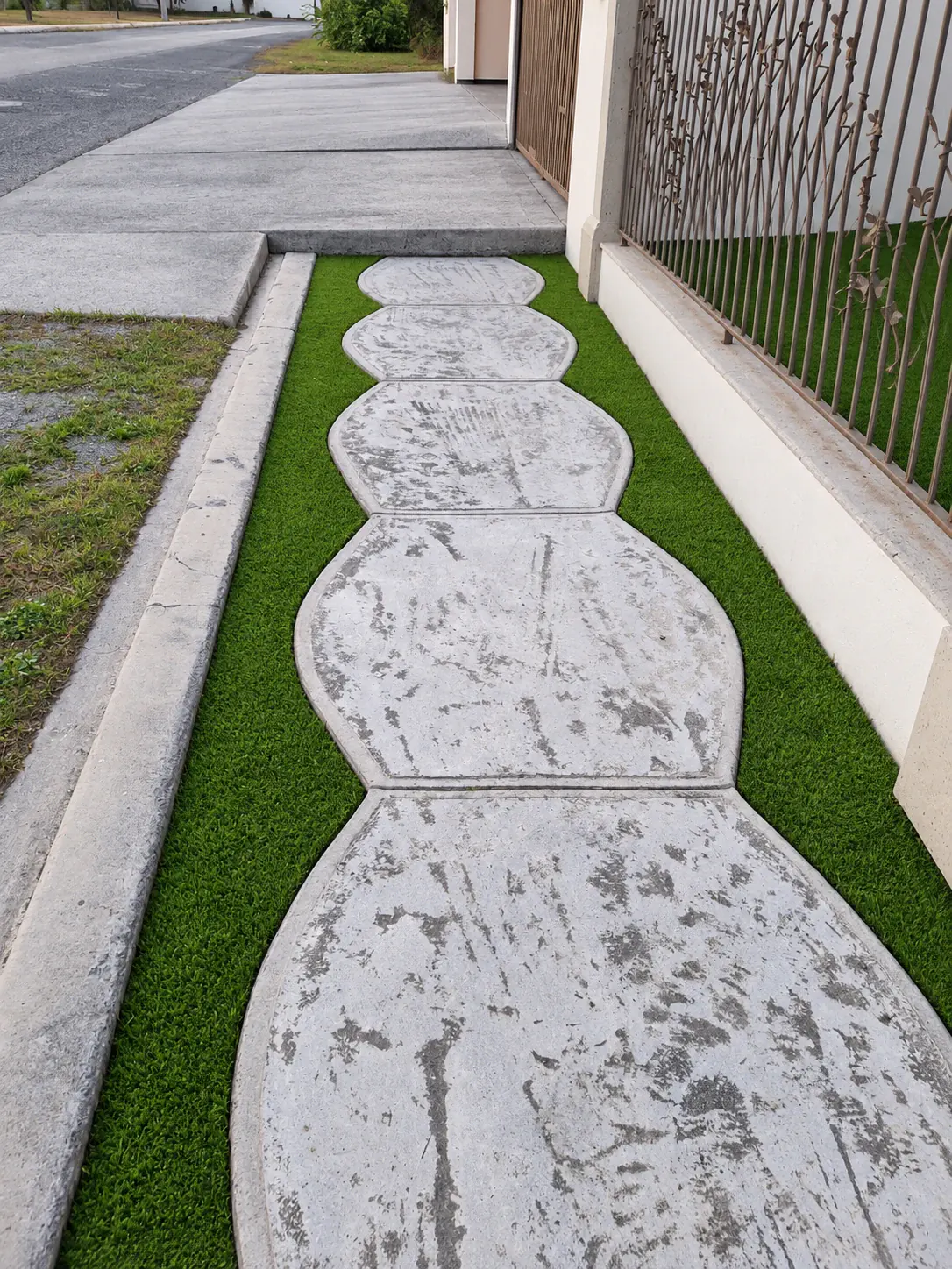 Sendero de losas integrado en un jardín de pasto sintético
